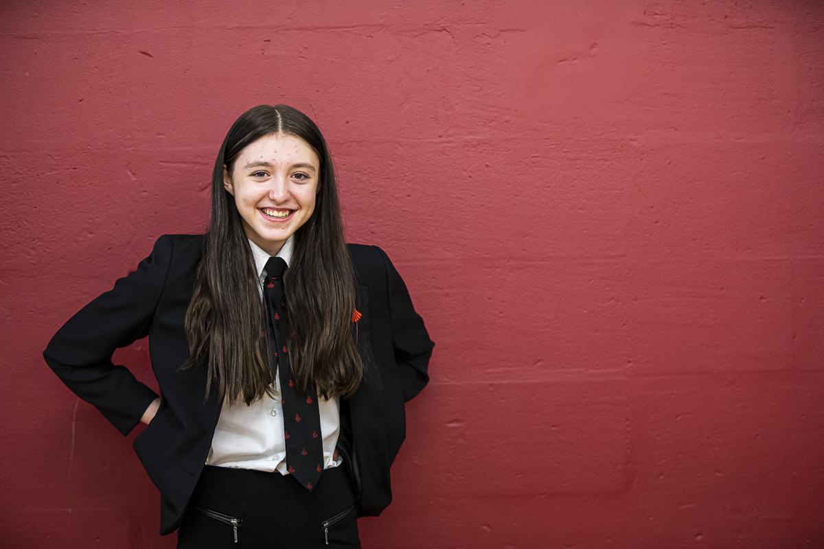 Girl standing in front of red background