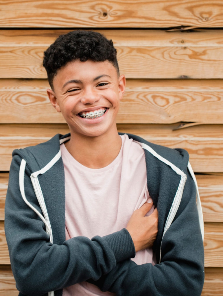 Boy smiling against fence