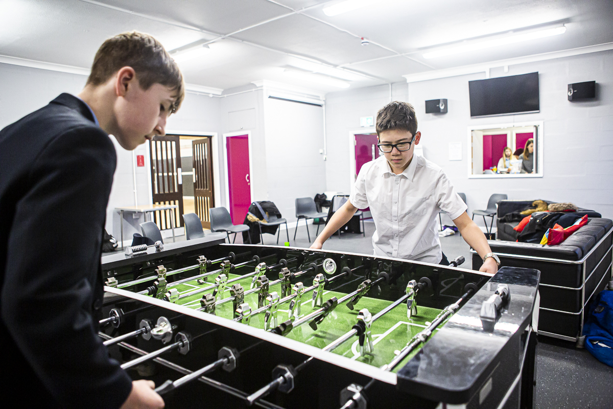 Two schoolboys playing table football