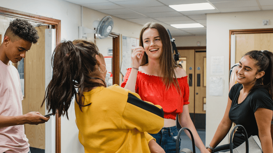 Teenagers gather in a communal area in a youth club.